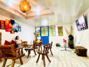 a woman sitting on a couch in a room filled with furniture at Alojamiento campestre San Miguel in San José del Guaviare