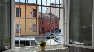 une fenêtre avec vue sur un bâtiment dans l'établissement Casa Zia Màpò, à Ferrare