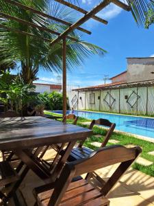 a picnic table and chairs next to a swimming pool at Casa Vila Prea Jericoacoara é logo ali in Prea