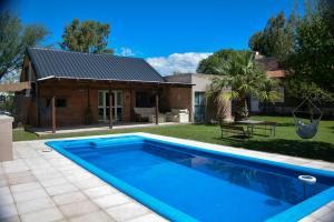 a swimming pool in front of a house at POSADA ROSSINA Habitaciones con baño privado y ambientes compartidos in San Rafael