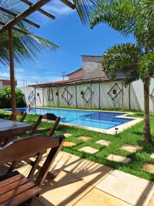 a patio with a table and chairs and a swimming pool at Casa Vila Prea Jericoacoara é logo ali in Prea