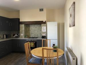 a kitchen with a table and chairs and a refrigerator at Comfortable home, town centre, free parking,Multiple Rooms in Cheltenham