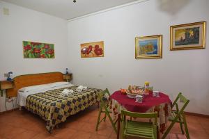 una camera da letto con un letto, un tavolo e delle sedie di B&B ABACO ad Alghero