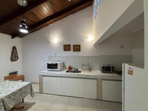 a kitchen with a sink and a microwave at Robinson Apartamentos SOLO FAMILIAS in Villa Carlos Paz