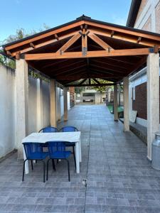 a pavilion with a table and chairs on a patio at Robinson Apartamentos SOLO FAMILIAS in Villa Carlos Paz