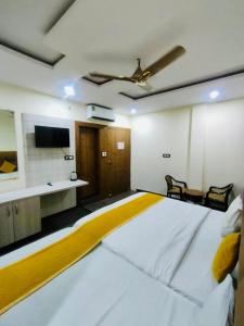 Hotel Wonder Premium Family Stay في ماثورا: غرفة مع سرير كبير وتلفزيون على الحائط