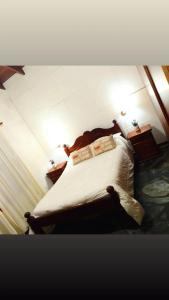 una camera da letto con un letto con lenzuola e cuscini bianchi di Cabaña Los Espinillos a Cortaderas