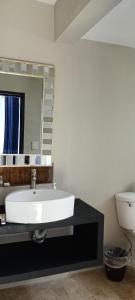 a bathroom with a sink and a mirror and a toilet at Hotel BLVD in Playa del Carmen