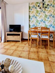 A television and/or entertainment centre at Strelitzia Apartment - ocean view & heated pool