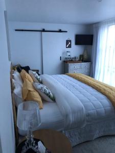 sypialnia z dużym białym łóżkiem z poduszkami w obiekcie Inniscort Retreat w mieście Cromwell