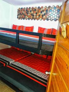 a bunk bed with red pillows and a wooden door at Aurum Hot Spring Resort in Los Baños