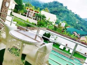 a balcony with a view of the water and mountains at Aurum Hot Spring Resort in Los Baños