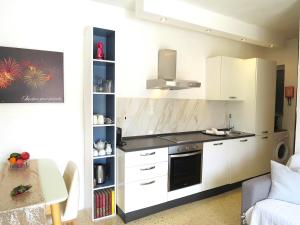 uma cozinha com armários brancos e um fogão em 3 Balconies South Views Special Bedroom 5 mins to beach em Mellieħa