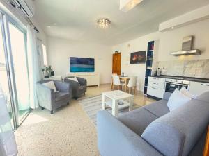 uma sala de estar com dois sofás e uma mesa em 3 Balconies South Views Special Bedroom 5 mins to beach em Mellieħa