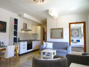 uma sala de estar com um sofá azul e uma cozinha em 3 Balconies South Views Special Bedroom 5 mins to beach em Mellieħa