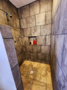 La salle de bains est pourvue d'une douche et de carrelage. dans l'établissement Villa Lakota By Natut Huasca, à Huasca de Ocampo