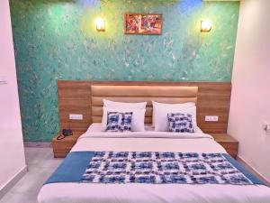 ニューデリーにあるHotel MARISA GRAND Near Delhi Airport BY Aero Homeの緑の壁、ベッド付きのベッドルーム1室
