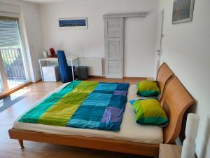 a large bed with a colorful comforter in a room at Doppelzimmer mit Seeblick - Neusiedlersee in Breitenbrunn