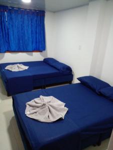 duas camas num quarto com lençóis azuis em Vivienda Turística el Refugio em Villavicencio