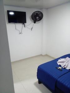 um quarto com uma cama azul e uma ventoinha em Vivienda Turística el Refugio em Villavicencio