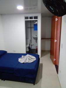 um quarto com uma cama azul e uma casa de banho em Vivienda Turística el Refugio em Villavicencio