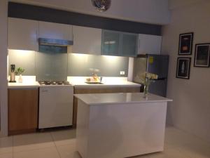 a kitchen with white cabinets and a counter top at Condominium at Carola in Nasugbu