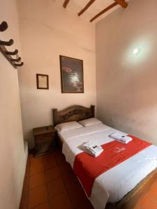 una camera con un letto con una coperta rossa di Hotel Casa Posada Don Chepe a San Gil