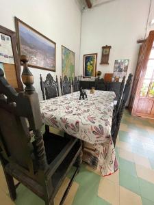una mesa de comedor con un gato sentado encima en Hotel Casa Posada Don Chepe, en San Gil