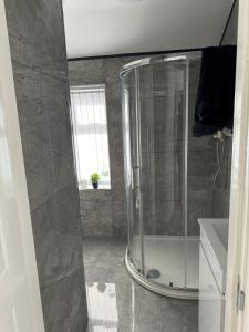 een glazen douche in een badkamer met een wastafel bij Home away from home in Leicester