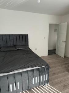 1 dormitorio con 1 cama grande y suelo de madera en Home away from home en Leicester