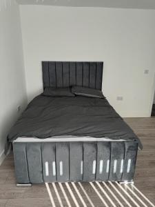 een bed met een zwart bedframe in een kamer bij Home away from home in Leicester