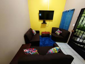 uma sala de estar com dois sofás e uma televisão em La Campana em San Miguel
