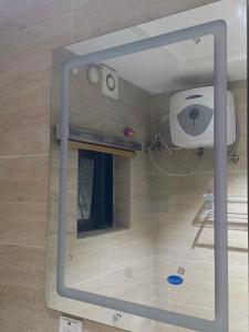 baño con ducha y ventana de cristal. en Ikad Hotel and Suite, en Lagos