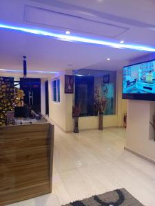 a lobby with a flat screen tv and a large screen at Ikad Hotel and Suite in Lagos