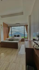 a large room with two beds and a large window at Devanora Hotel & Resto in Kintamani