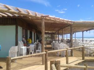 eine Terrasse mit weißen Stühlen und Menschen, die am Strand sitzen in der Unterkunft Suite d'Artistes in Imbassai + 24 Fotos