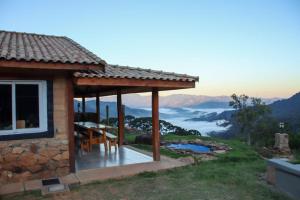 a house with a deck with a view of the mountains at Cabana do Camelo in São Bento do Sapucaí