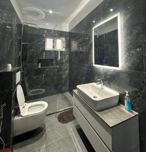 a bathroom with a white toilet and a sink at Nardi Guesthouse in Ksamil