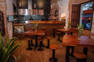 un bar con mesas de madera y taburetes en un restaurante en Naif Boutique Hotel, en Antigua Guatemala