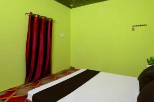 a bedroom with a bed with a red curtain at SPOT ON Mahadev Hotel in Prayagraj