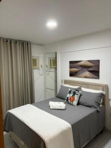 um quarto com uma cama grande e lençóis cinzentos em Infinity APT 503 em Maceió