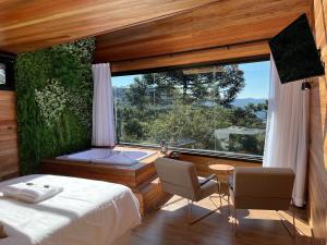 a bedroom with a tub and a bed and a window at Cabanas Urubici in Urubici