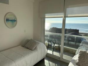 a bedroom with a bed and a view of the ocean at Al Mar in Pinamar