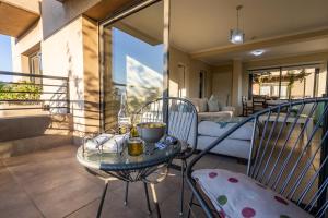 eine Terrasse mit einem Tisch und Stühlen auf dem Balkon in der Unterkunft Andes Vista tu lugar en Mendoza in Godoy Cruz