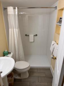 a white bathroom with a toilet and a sink at The Boards AC in Atlantic City +21 photos