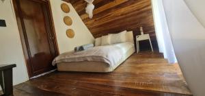 een slaapkamer met een bed en een houten vloer bij Dreamvilles Ecovillage Las Galeras in Las Galeras