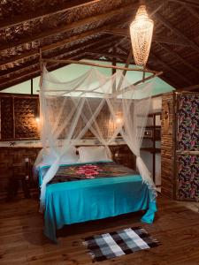 a bedroom with a bed with a canopy at Pension TUPUNA in Haapu