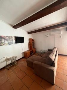 a living room with a couch and a flat screen tv at Hôtel Restaurant Douce France in Saint Alban Auriolles