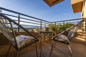 einen Balkon mit 2 Stühlen und einem Tisch in der Unterkunft Andes Vista tu lugar en Mendoza in Godoy Cruz