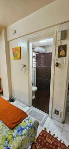 a bathroom with a bed and a toilet in a room at Laxmi Happy Home in Pune